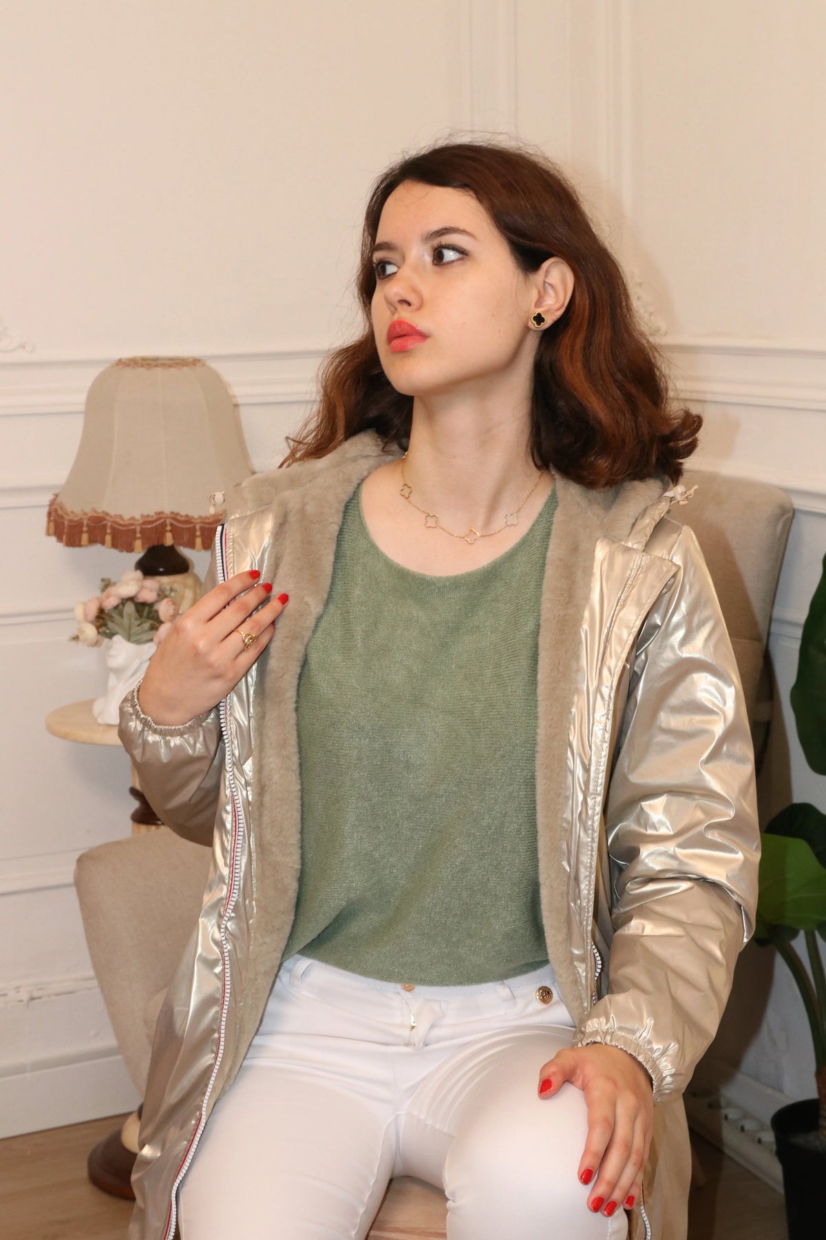 Femme portant une veste métallisée argentée avec doublure en polaire et un haut vert olive.